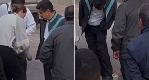 Exhiben a Hugo Aguilar mientras asistentes le limpian los zapatos en acto oficial